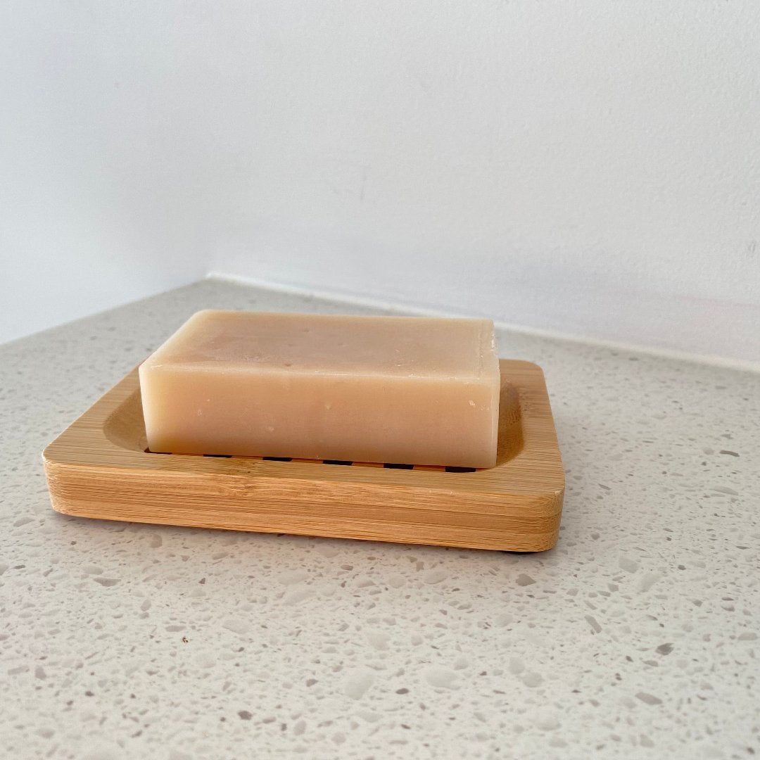 Bamboo soap holder in a bathroom setting, displaying its water-resistant design and clear, textured bamboo pattern.