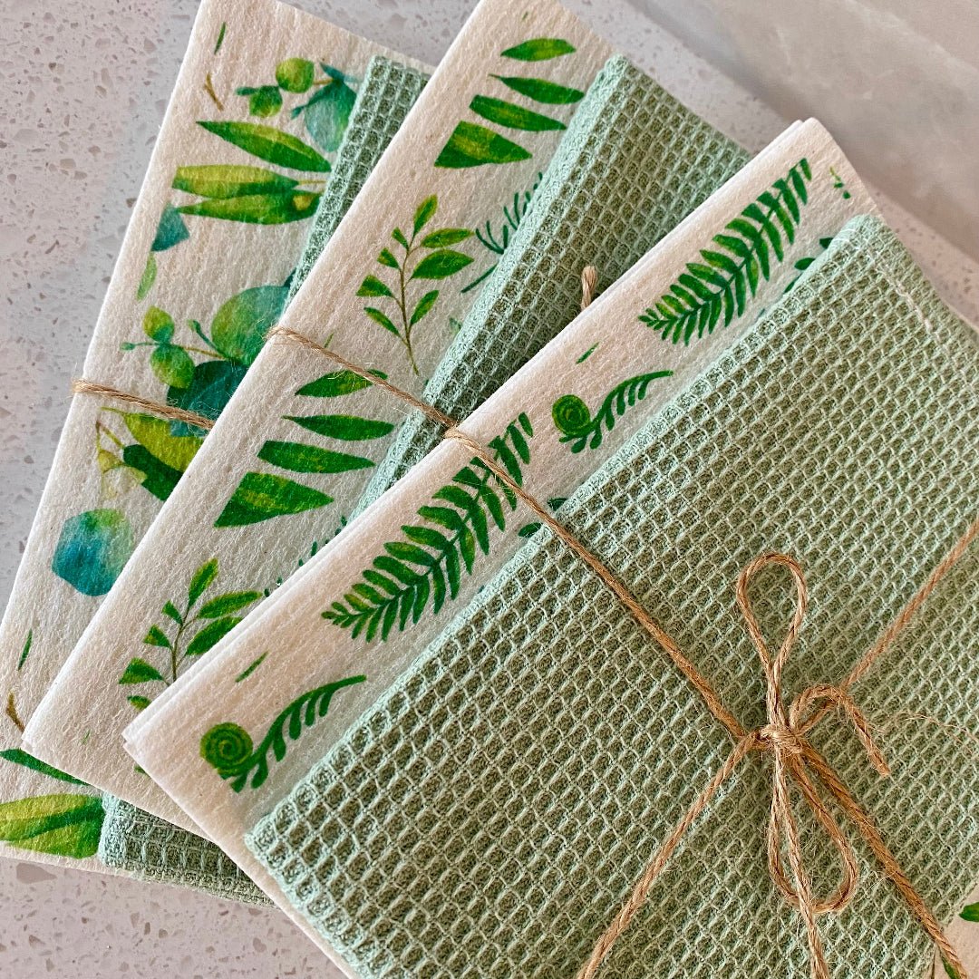 Pair of reusable absorbent dishcloths with a green leaf design for sustainable cleaning.