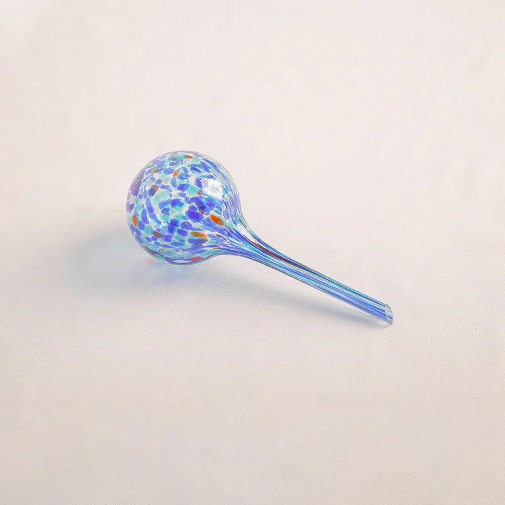 Elegant hand-blown glass watering globe in deep blue shades, designed to keep your plants hydrated in style.