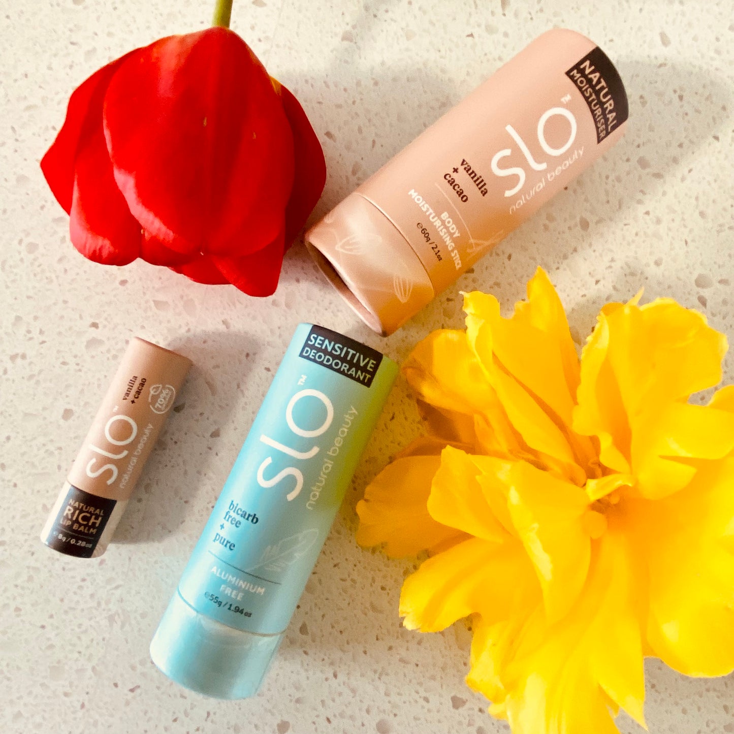 Three-piece natural vanilla self-care bundle by Slo Naturals: moisturiser, deodorant, and lip balm.