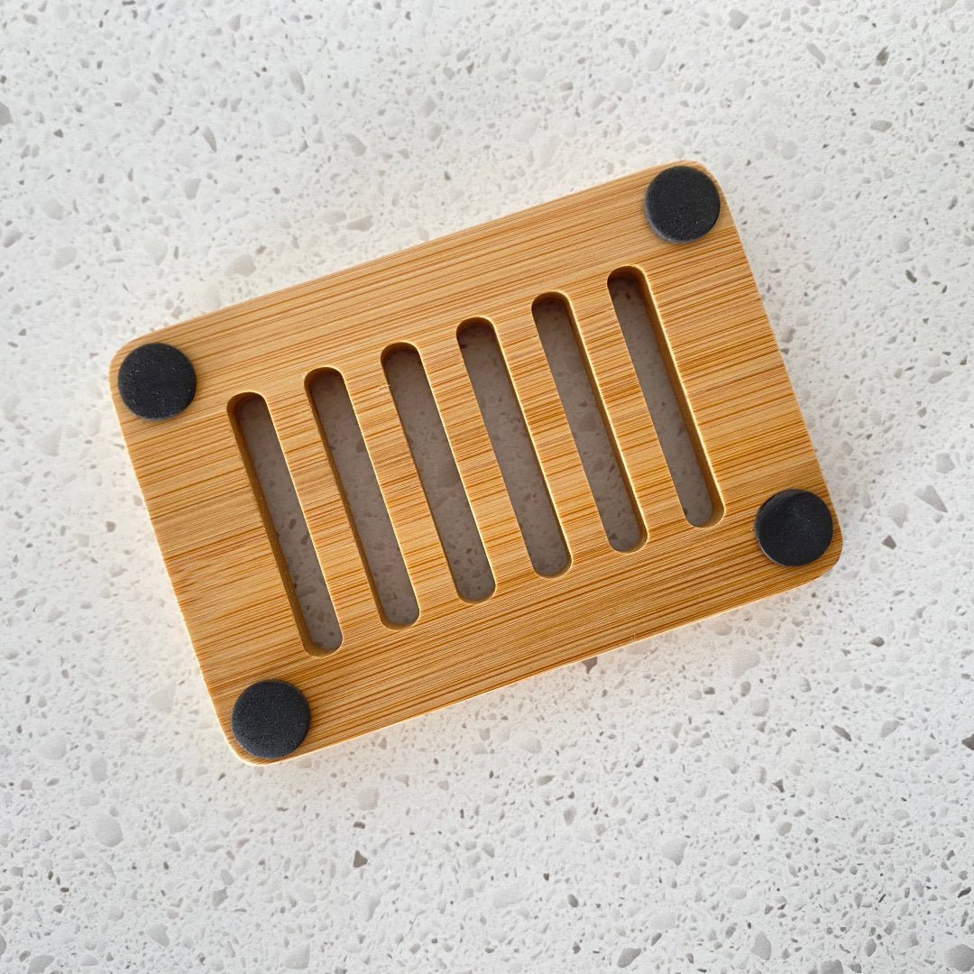 Underneath close-up of our bamboo soap holder showing the natural grain and smooth finish, highlighting its lightweight, retro aesthetic.