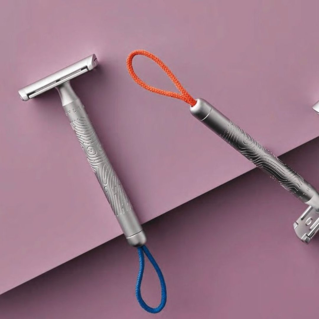 COMPANION unisex safety razor with coral cotton hanging cord, non-slip metal handle, and closed comb design for face and body shaving.