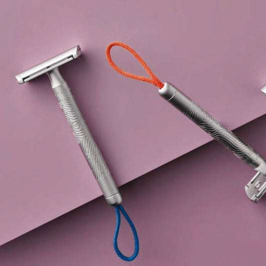 COMPANION unisex safety razor with coral cotton hanging cord, non-slip metal handle, and closed comb design for face and body shaving.