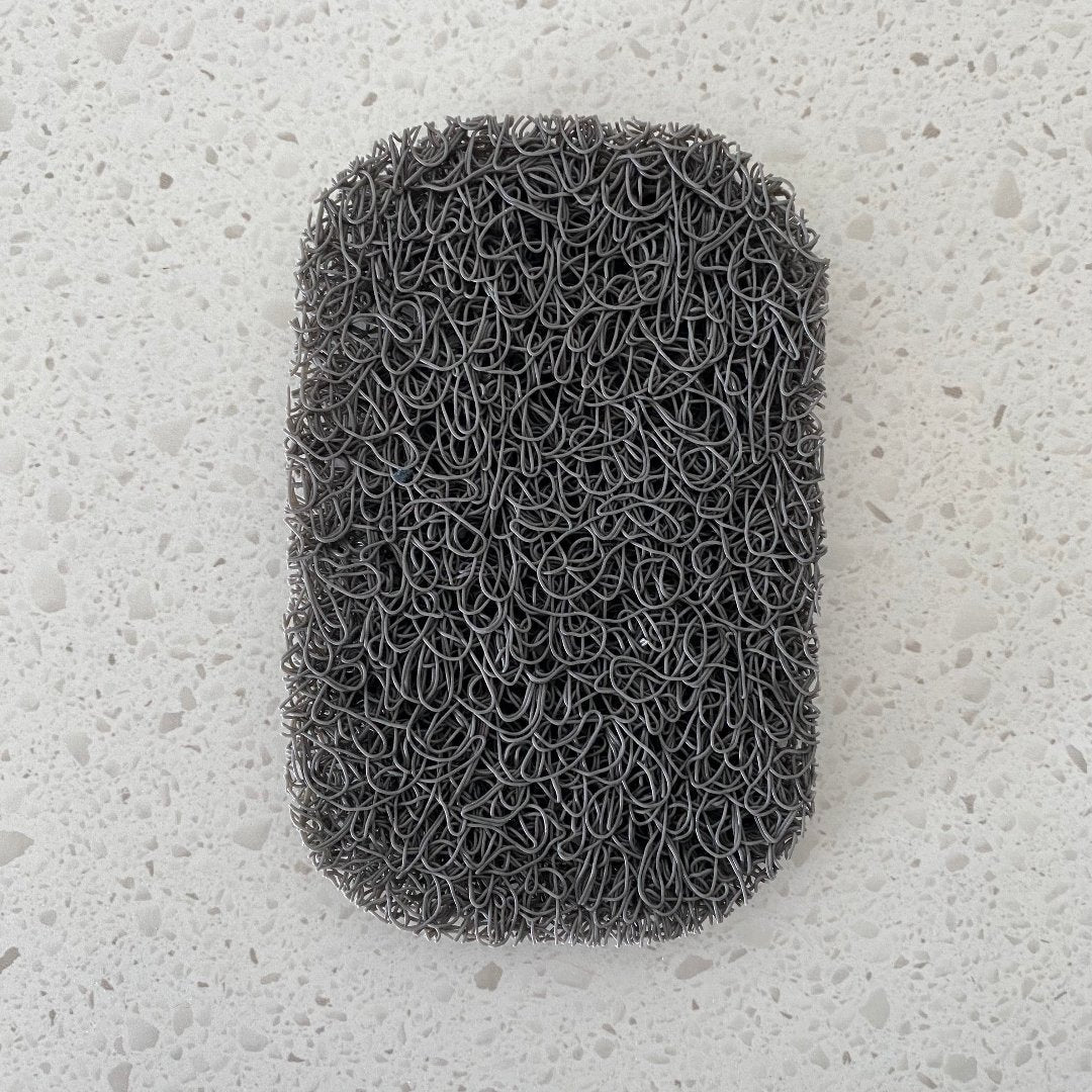 Porous PVC soap saver lift pad elevating a bar of soap to promote drainage and keep the soap dry, suitable for use in a soap dish or directly on a basin.