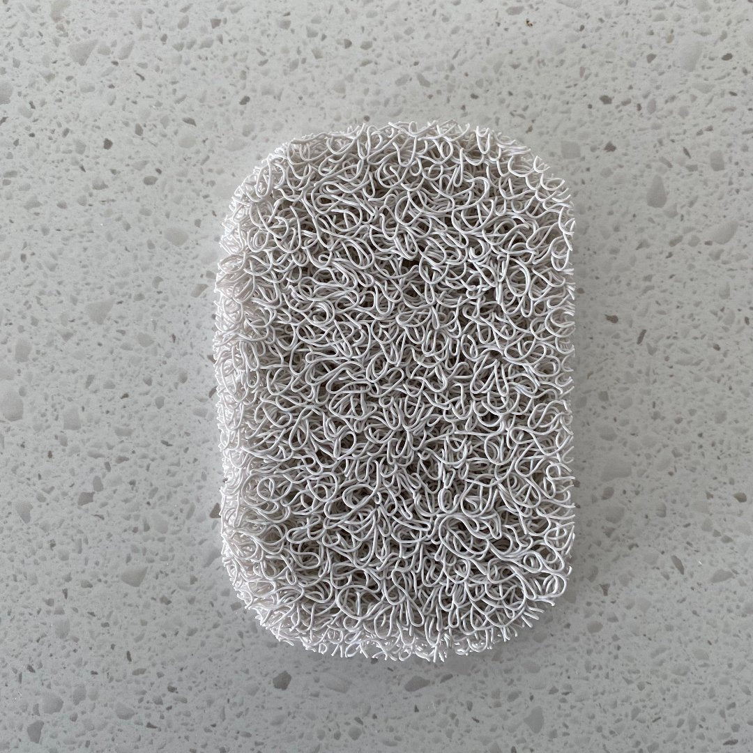 Porous PVC soap saver lift pad elevating a bar of soap to promote drainage and keep the soap dry, suitable for use in a soap dish or directly on a basin.