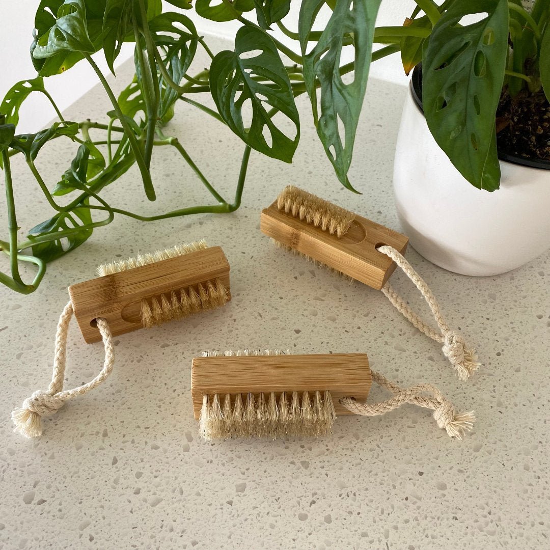 Close-up of the wooden nail brush showing its durable construction and compact size, with a small rope handle for easy storage.